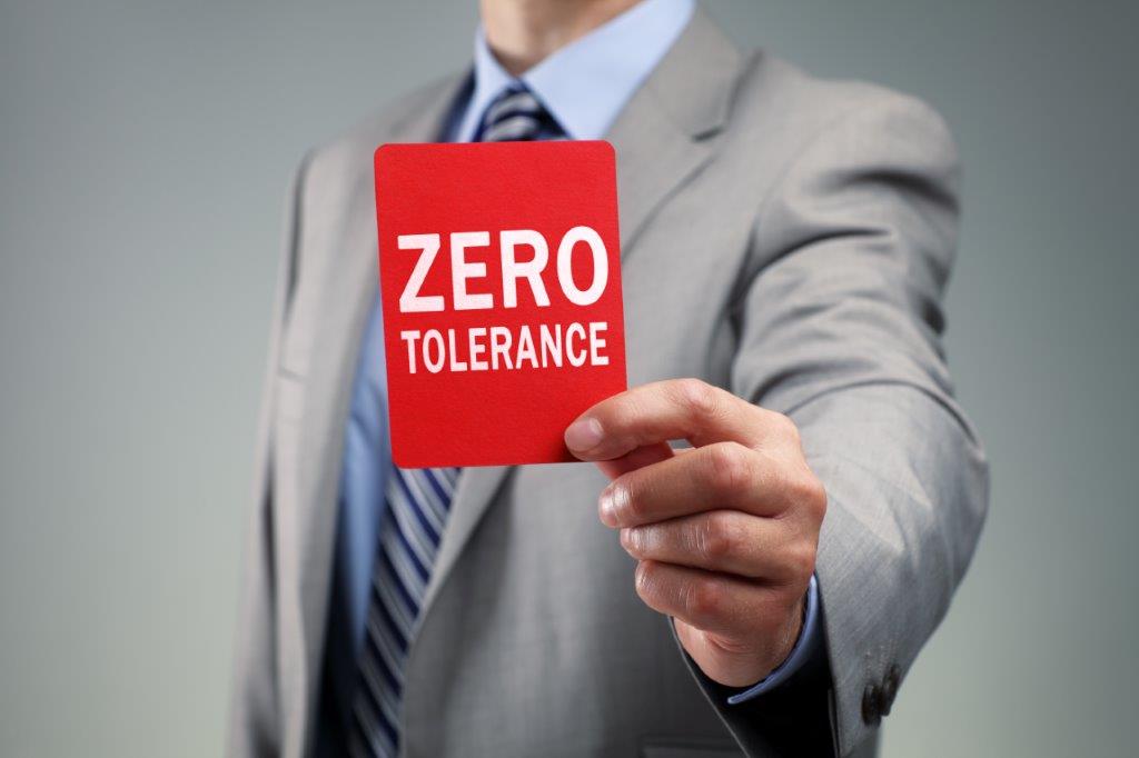 Man holding red poster with 'Zero Tolerance' on it