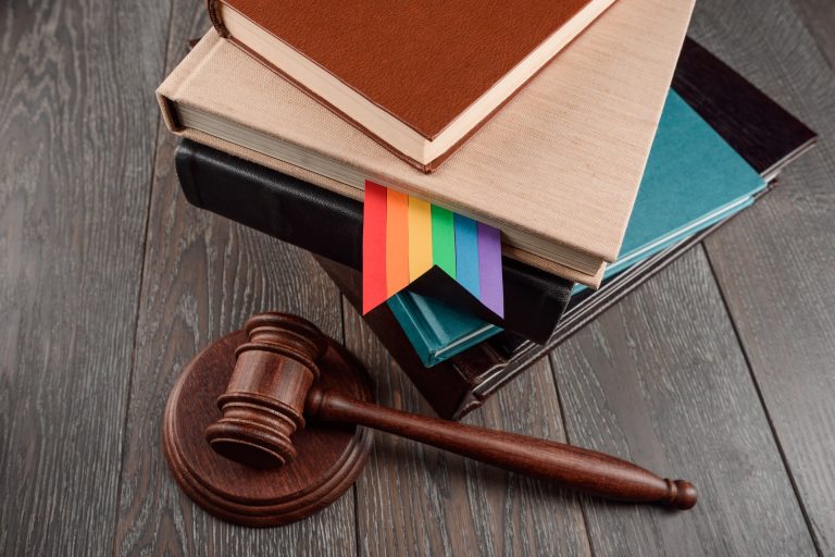 Stack of books with a rainbow flag and a gavel